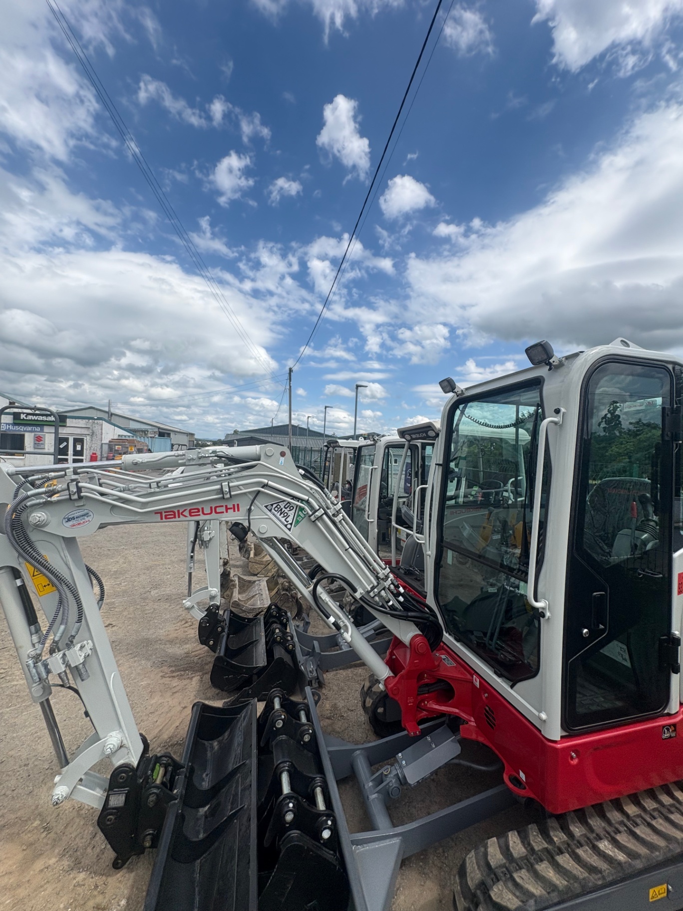 Takeuchi mini diggers with buckets in the yard