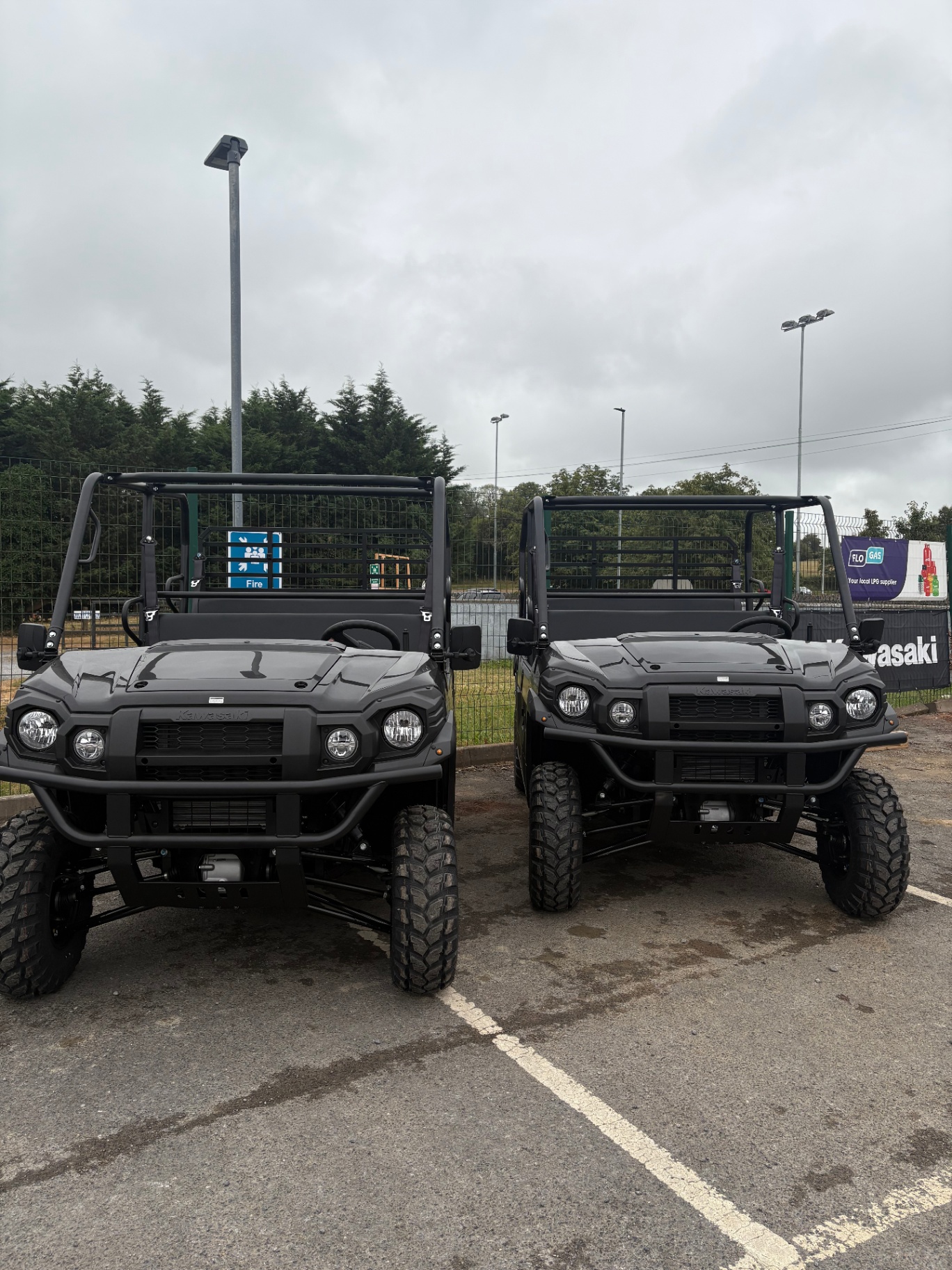 Two Kawasaki Mule UTVs side by side in our yard