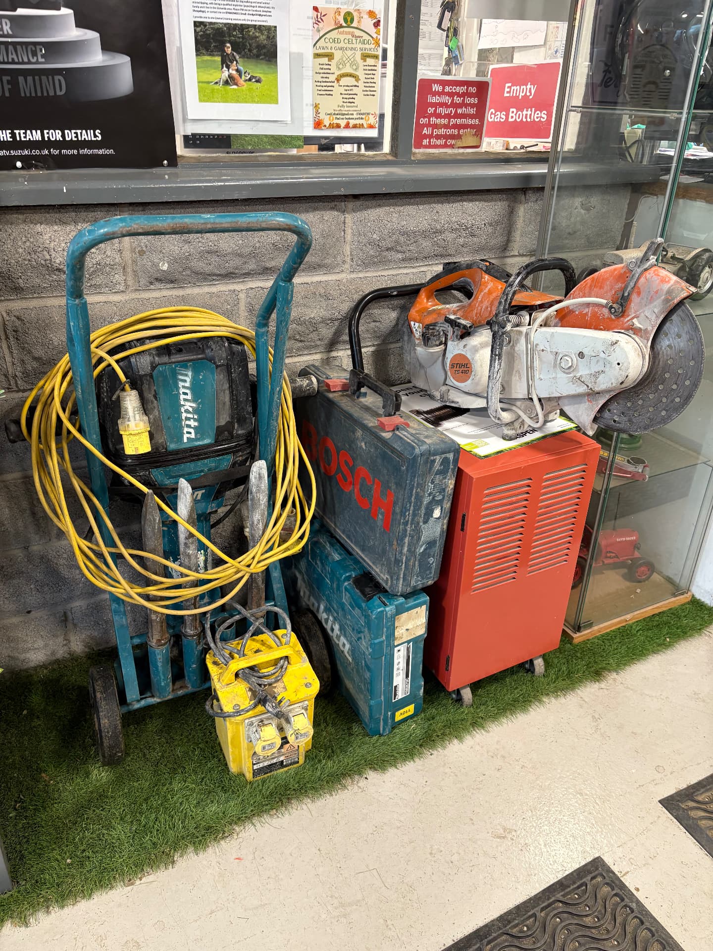 Hand-held breakers, a cut-off saw and transformers outside our shop